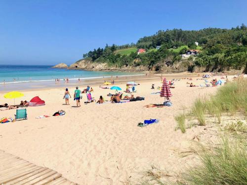 a group of people laying on a beach at The Cliffs - A Pedrinha in Viveiro