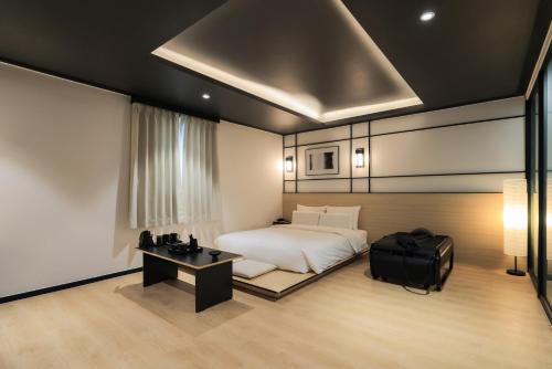 a bedroom with a bed and a desk and a bed sidx sidx sidx at Mitasuya Ryokan Hotel Gumi by AanK in Gumi