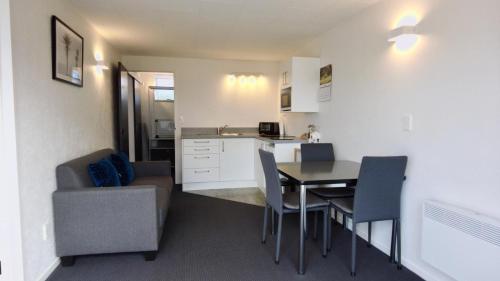 a kitchen and dining room with a table and a couch at 554 Moana Court Motel in Invercargill