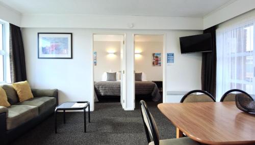 a hotel room with a couch and a bed at 554 Moana Court Motel in Invercargill