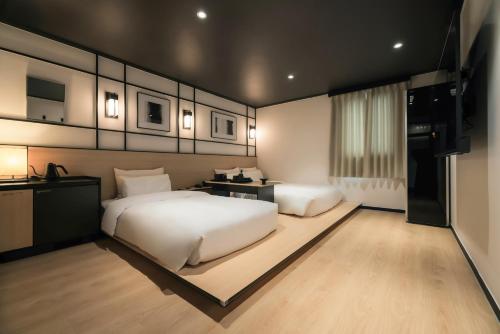 a large bedroom with two beds and a television at Mitasuya Ryokan Hotel Gumi by AanK in Gumi
