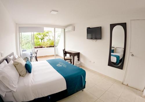 a bedroom with a large bed and a mirror at Hotel del Llano in Villavicencio