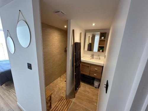 une salle de bain avec un lavabo et un miroir dans l'établissement Maison rénovée proche plage et centre-ville, 8 pers, 4 ch, jardin, terrasse, wifi, équipements bébé - FR-1-194-287, à La Tranche-sur-Mer