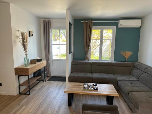 un salon avec un canapé et une table dans l'établissement Maison rénovée proche plage et centre-ville, 8 pers, 4 ch, jardin, terrasse, wifi, équipements bébé - FR-1-194-287, à La Tranche-sur-Mer