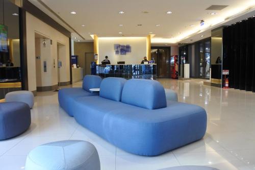 a blue couch in the middle of a lobby at Holiday Inn Express Taichung Park by IHG in Taichung