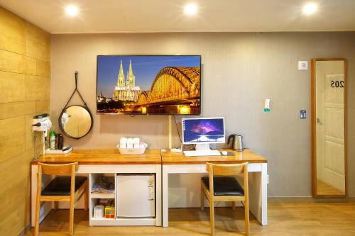 a desk with a computer on it in a room at Smile Hotel in Jeonju