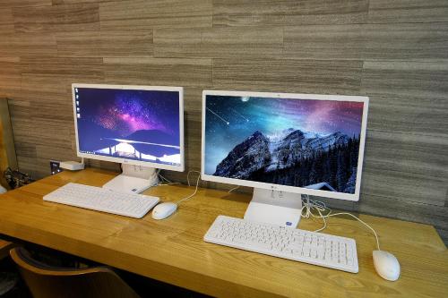 two computer monitors sitting on top of a wooden table at Smile Hotel in Jeonju