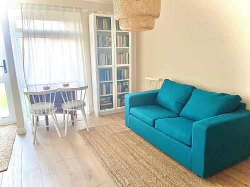 a living room with a blue couch and a table at Spacious garden 2 bed, sleeps 5 in Oxford