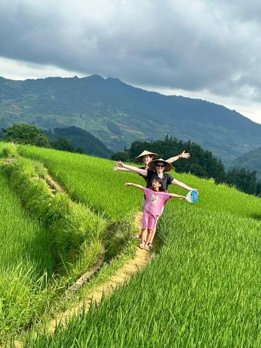 a group of people walking through a field at Bac Ha Lodge Retreat in Bắc Hà