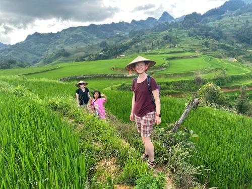 a group of people walking on a rice field at Bac Ha Lodge Retreat in Bắc Hà