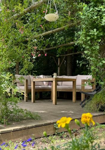 a wooden bench sitting in a garden with flowers at Ferienwohnung im Thermenland in Kleinkögeln