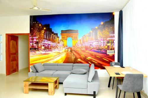 a living room with a couch and a picture of a street at Paris in Lomé