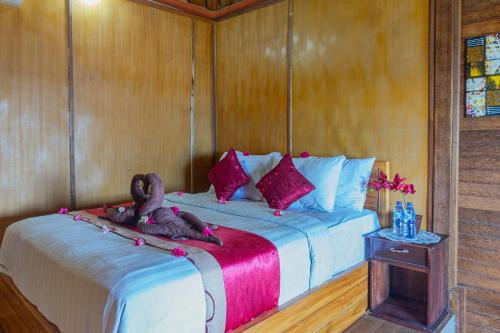 a bedroom with a bed with a dog laying on it at Manta Cottages with Sea View in Nusa Penida