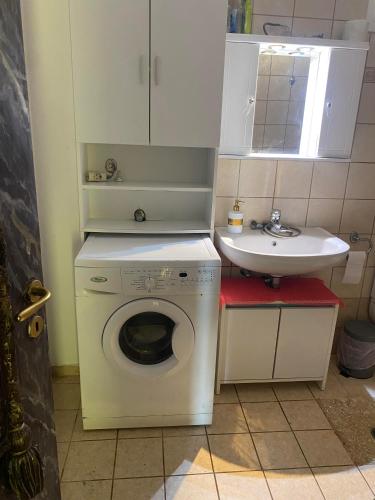 a small bathroom with a washing machine and a sink at Stefania's house in Agia Effimia