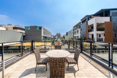 a patio with a table and chairs on a balcony at Happiness Romantic B&B in Donggang