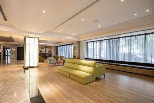 a lobby with a couch and a table and chairs at CHECK inn Taichung Wenxin Zhongqing in Taichung