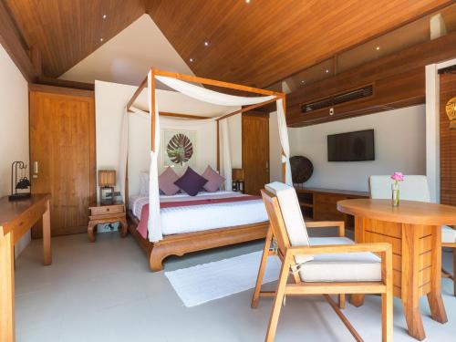a bedroom with a bed and a desk and a table at Baan Puri - SHA Extra Plus in Lipa Noi