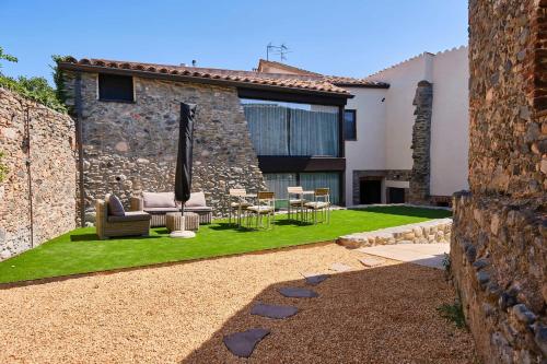 a house with a garden with a couch and chairs at Hotel Molí Cardedeu in Cardedeu