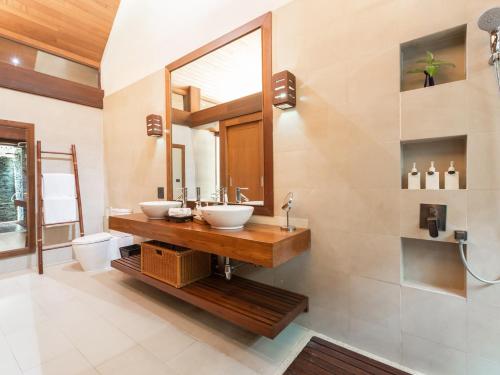 a bathroom with two sinks and a mirror at Baan Puri - SHA Extra Plus in Lipa Noi