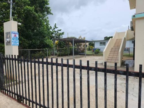 a black fence in front of a building with stairs at Stargaze Comfort Under the Stars & Arcade Room in Aguadilla