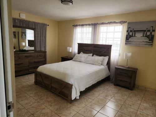 a bedroom with a large bed and a mirror at Stargaze Comfort Under the Stars & Arcade Room in Aguadilla