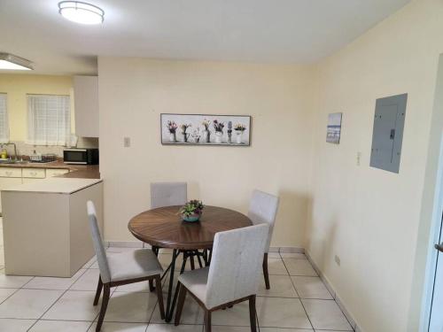 a kitchen with a wooden table and chairs in a room at Stargaze Comfort Under the Stars & Arcade Room in Aguadilla
