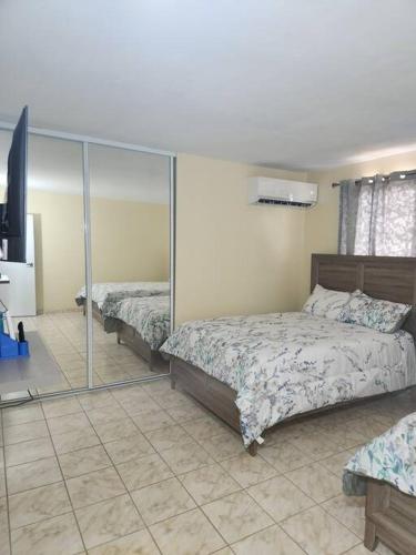 a bedroom with two beds and a mirror at Stargaze Comfort Under the Stars & Arcade Room in Aguadilla