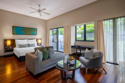 a room with a bed and a couch and a table at Mangala Estate Boutique Resort - Small Luxury Hotels of the World in Kuantan