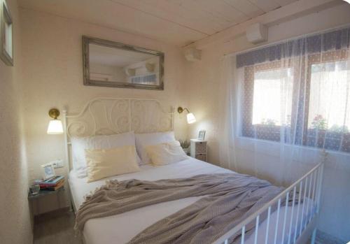 a bedroom with a white bed and a mirror at Kuća za odmor Brigitaa in Jezera