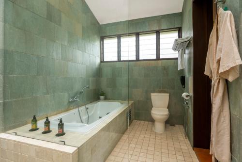 a bathroom with a tub and a toilet at Mangala Estate Boutique Resort - Small Luxury Hotels of the World in Kuantan