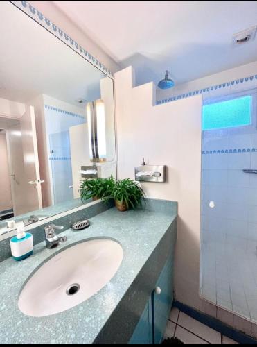 a bathroom with a sink and a mirror at T1 BIS RDC Carayou Marina Pointe du Bout in Les Trois-Îlets