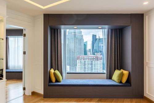 a window seat with a view of a city at Rembrandt Hotel Bangkok in Bangkok