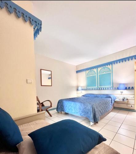 a bedroom with a blue bed and a window at T1 BIS RDC Carayou Marina Pointe du Bout in Les Trois-Îlets
