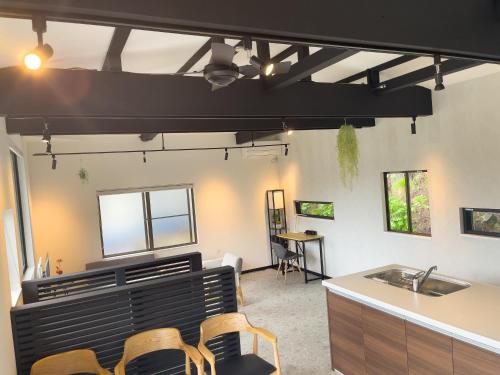 une chambre avec des chaises et une cuisine avec un évier dans l'établissement リノベーションされた一軒家で富士山と自然 BBQを満喫 villa voyage, à Azagawa