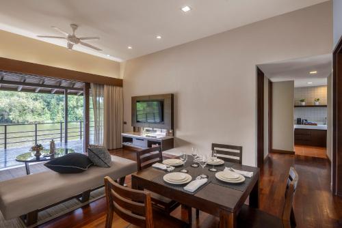 a dining room and living room with a table and chairs at Mangala Estate Boutique Resort - Small Luxury Hotels of the World in Kuantan