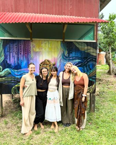 a group of women standing in front of a mural at Chaikoni Lodge in Pucallpa