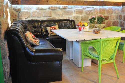 a black leather couch sitting next to a table and a table and chair at Villa Kada in Belogradchik