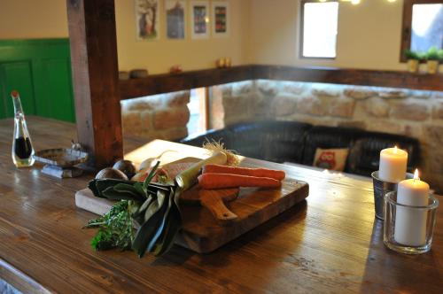 a wooden table with a cutting board with carrots and candles at Villa Kada in Belogradchik