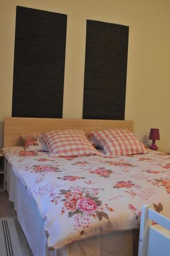 a bedroom with a large bed with two windows at Villa Kada in Belogradchik