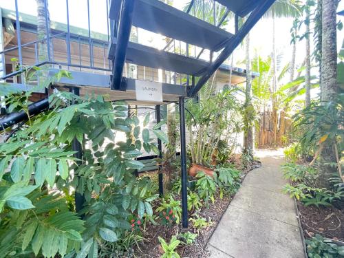 a building with a sign in the middle of a garden at Cairns City Motel in Cairns