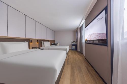 a hotel room with two beds and a projection screen at Atour X Hotel Changsha Jintai Plaza Metro Station Wanjiali Middle Road in Changsha