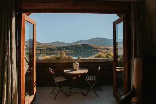 a table and chairs on a balcony with a view at Stoneridge Estate in Queenstown