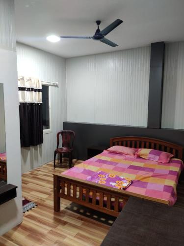 a bedroom with a bed and a ceiling fan at Vidhara Rooms in Trivandrum