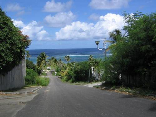 an empty street with a view of the ocean at Caraïbes - RDC in Le Moule