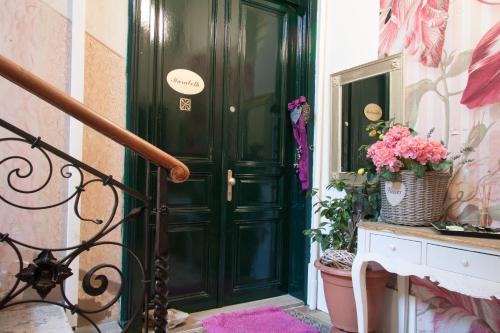 a green door in a hallway with pink flowers at Marabeth Guest House in Zagreb