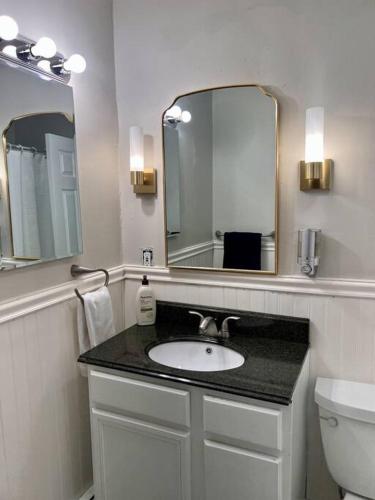 a bathroom with a sink and a mirror at Spacious 4BR Near Subway, Sleeps 8per Easy Access to Downtown Boston in Boston