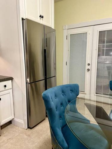 a kitchen with a glass table and a blue chair at Spacious 4BR Near Subway, Sleeps 8per Easy Access to Downtown Boston in Boston