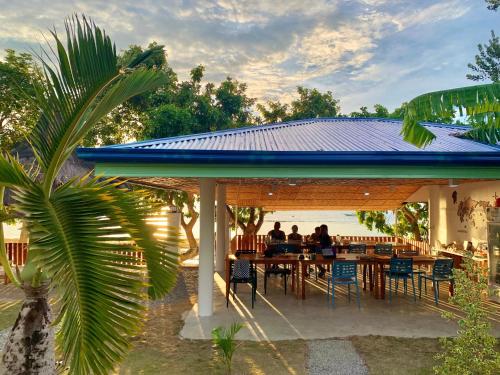 a group of people sitting at a table under a blue roof at The Shuim Dive Resort Moalboal in Moalboal