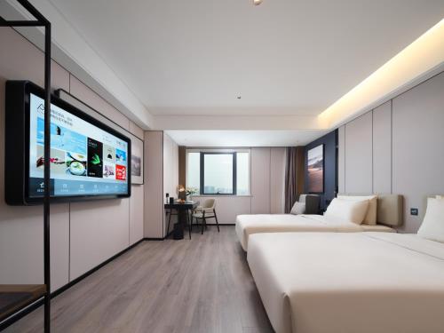 a hotel room with two beds and a flat screen tv at Atour Hotel Zhengzhou Erqi Plaza David City in Zhengzhou