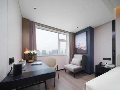 a hotel room with a desk and a bed at Atour Hotel Zhengzhou Erqi Plaza David City in Zhengzhou